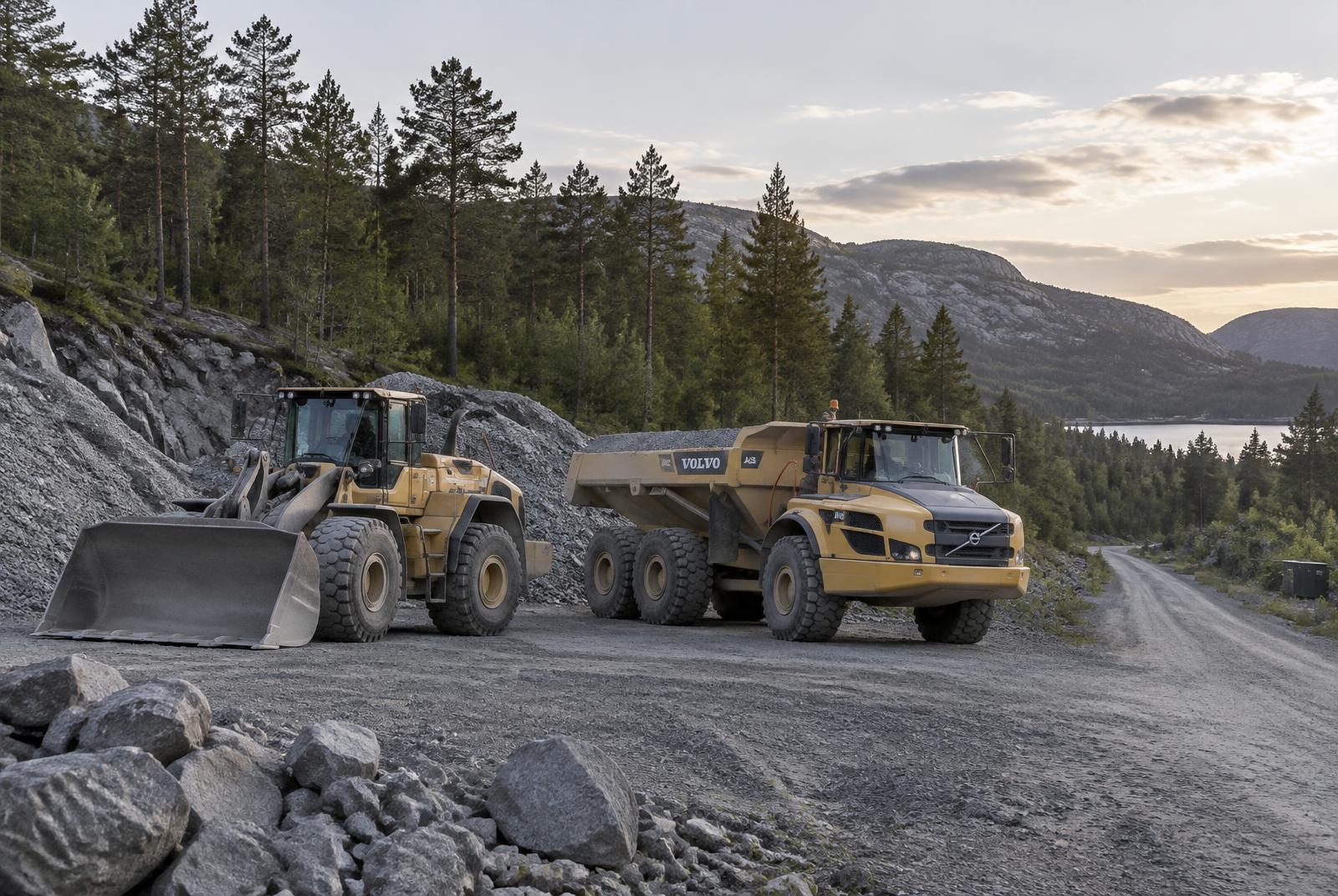 Hjullaster og dumper ved en grusvei i skogen